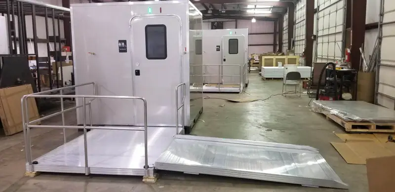 ADA restroom unit with an extended ramp inside a fabrication shop