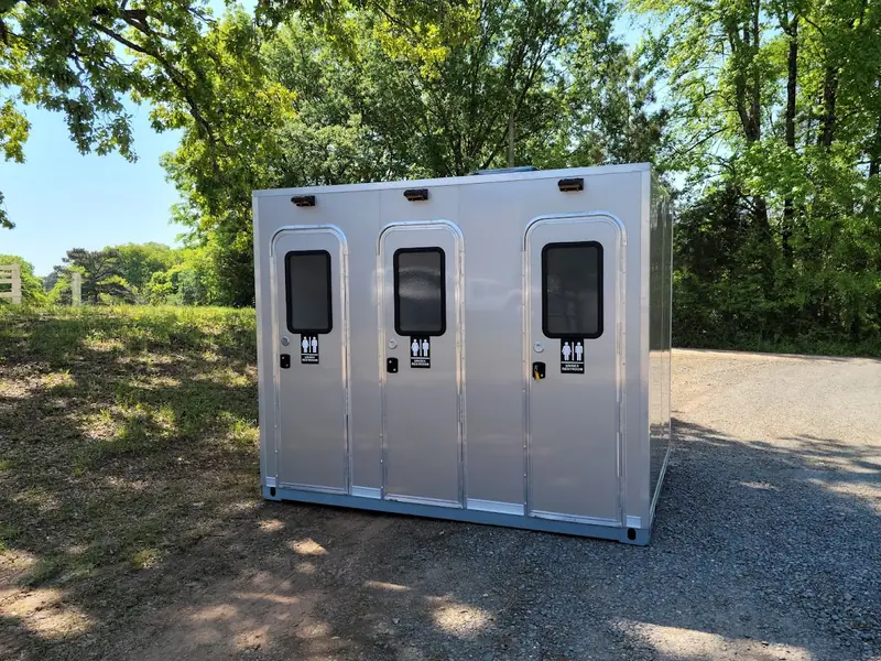 Three-stall restroom skid with an ADA stall on gravel