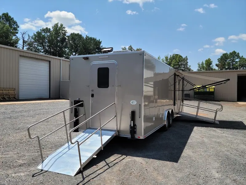 Large restroom trailer with ramps and railings at both doors