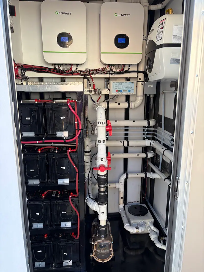 Battery bank and inverters in the mechanical room of an off grid restroom skid