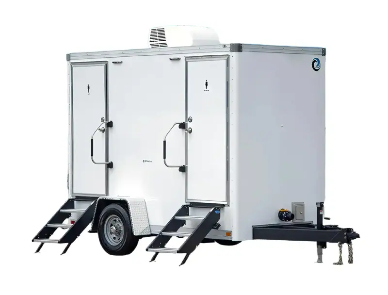 The 2 private room shower restroom trailer features two separate doors, entry steps, a ventilation unit on top, and a front tow hitch—perfect for events needing accessible or ADA-compliant restroom solutions.