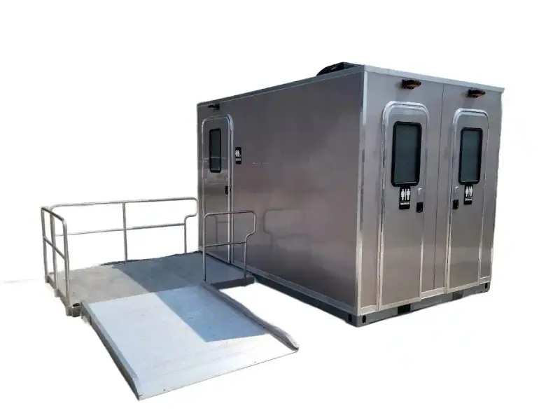 The CI 12 - 3 Stall ADA Restroom Skid (12 ft) features a metallic exterior, two restroom-symbol doors, and an accessible ramp for convenient ADA restroom access at the entrance.