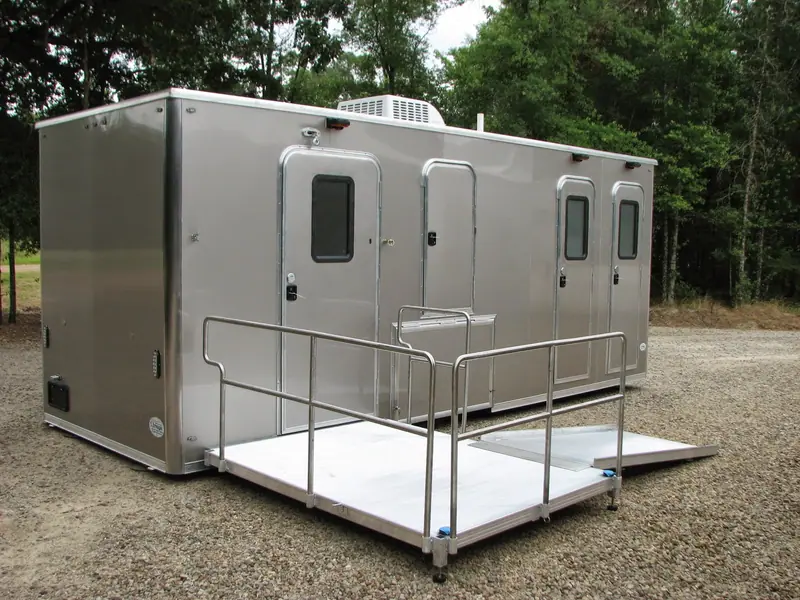 Omega ADA restroom trailer with three doors and an accessible ramp