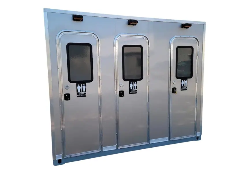 The CI 10 - 3 Stall Restroom Skid (10 ft) offers three private stalls with male and female signage, plus an ADA-accessible restroom to ensure comfort and accessibility for all guests.